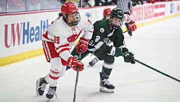 Wisconsin Badgers center Marianne Picard (18) handles the puck with Bemidji State Beavers defender Makenna Deering (2) in pursuit in the first period of a WCHA first-round game Saturday, March 1, 2025, at LaBahn Arena in Madison, Wisconsin.