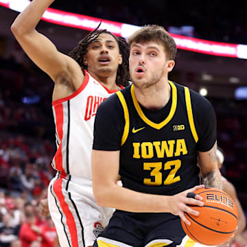 Jan 27, 2025; Columbus, Ohio, USA;  Iowa Hawkeyes forward Owen Freeman (32) controls the ball as Ohio State Buckeyes forward Devin Royal (21) defends during the first half at Value City Arena. Mandatory Credit: Joseph Maiorana-Imagn Images