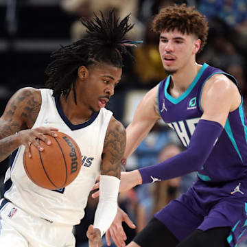 Nov 10, 2021; Memphis, Tennessee, USA; Memphis Grizzles guard Ja Morant (12) dribbles as Charlotte Hornets guard LaMelo Ball (2) defends during the first half at FedExForum. Mandatory Credit: Petre Thomas-Imagn Images