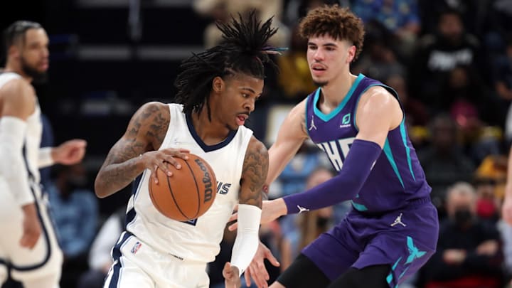 Nov 10, 2021; Memphis, Tennessee, USA; Memphis Grizzles guard Ja Morant (12) dribbles as Charlotte Hornets guard LaMelo Ball (2) defends during the first half at FedExForum. Mandatory Credit: Petre Thomas-Imagn Images