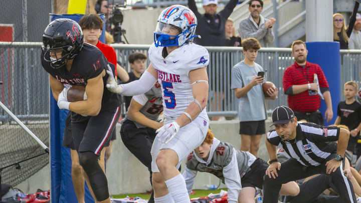 Lake Travis' Josiah Thomas (35) catches over Westlake safety Payton Luther (5) in the 6A D1 quarterfinal on Dec. 2, 2023.