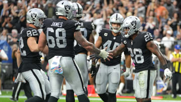 Raiders RB Josh Jacobs (28) is congratulated by Las Vegas Raiders center Andre James (68) after scoring a touchdown against the Chicago Bears.
