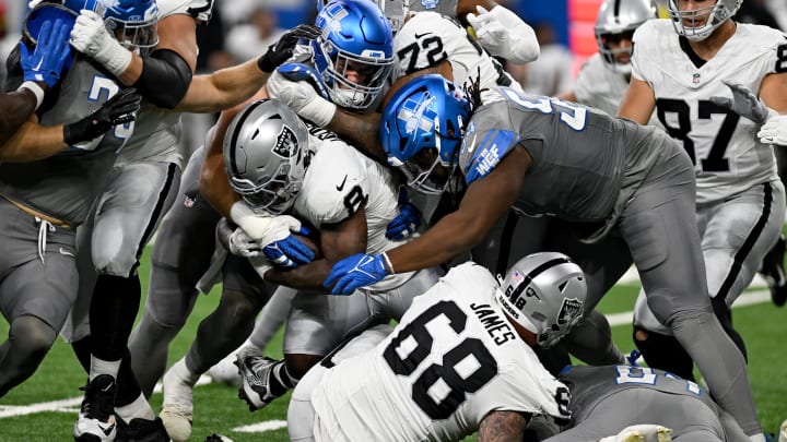 Las Vegas Raiders running back Josh Jacobs (8) gets tackled by Detroit Lions defensive end John Cominsky (79) and defensive tackle Alim McNeill (54).