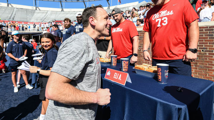 Joey Chestnut, left, greets Ole Miss offensive lineman Eli Acker (73) during the Ole Miss Grove Bowl Games at Vaught-Hemingway Stadium in Oxford, Miss., on Saturday, Apr. 13, 2024.