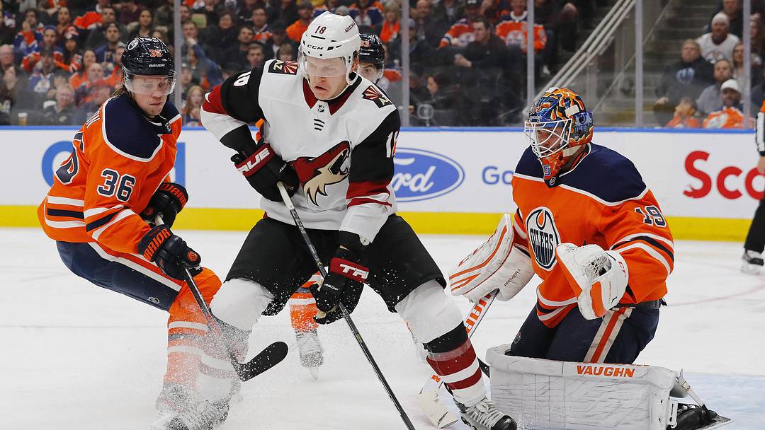 Nov 4, 2019; Edmonton, Alberta, CAN;  Arizona Coyotes forward Christian Dvorak (18) battles for a loose puck with Edmonton Oilers defensemen Joel Persson (36) in front of goaltender Mikko Koskinen (19) during the second period at Rogers Place. Mandatory Credit: Perry Nelson-Imagn Images