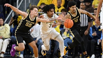 Nov 3, 2025; Ann Arbor, Michigan, USA; Michigan Wolverines guard Elliot Cadeau (3) battles for a loose ball with Oakland Golden Grizzlies guards Brody Robinson (55) and  Brett White (10) in the first half at Crisler Center. Mandatory Credit: Lon Horwedel-Imagn Images