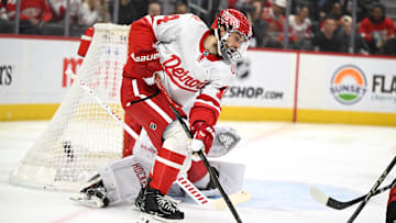 Mar 4, 2025; Detroit, Michigan, USA;  Detroit Red Wings center Tyler Motte (14) clears the puck from in front of their goal against the Carolina Hurricanes in the first period at Little Caesars Arena. Mandatory Credit: Lon Horwedel-Imagn Images