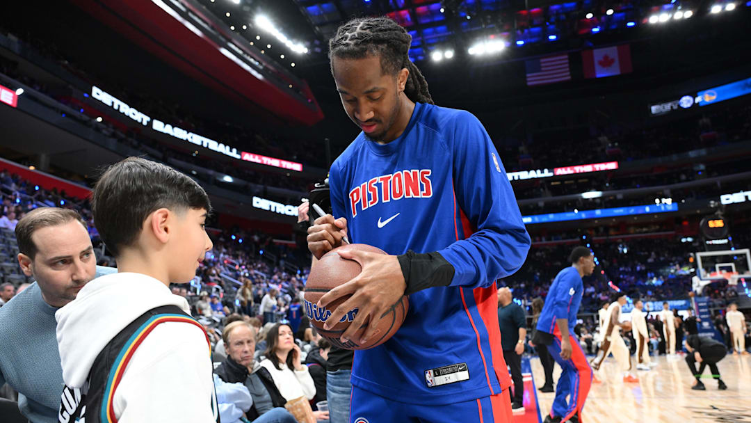 Mar 20, 2026; Detroit, Michigan, USA;  Detroit Pistons guard Daniss Jenkins (24) signs a basketball for a young fan before their game against the Golden State Warriors at Little Caesars Arena. Mandatory Credit: Lon Horwedel-Imagn Images