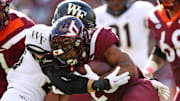 Oct 14, 2023; Blacksburg, Virginia, USA; Virginia Tech Hokies running back Bhayshul Tuten (33) runs the ball against Wake Forest Demon Deacons defensive back Nick Andersen (45) during the first quarter at Lane Stadium.