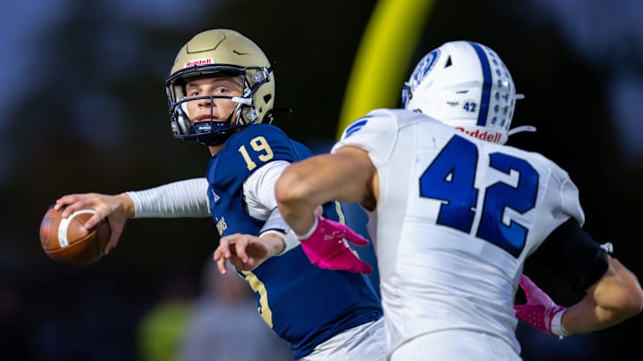 Tri-West Hendricks High School junior Jack Sorgi (19) is pressured in the backfield by Bishop Chatard High School junior Cole Lunsford (42) during the first half of an IHSAA varsity football game, Friday, Oct. 10, 2025, at Tri-West Hendricks High School.
