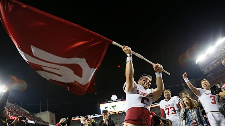 Former Oklahoma quarterback Baker Mayfield waves the school's flag after a win. Former Oklahoma quarterback Baker Mayfield waves the school's flag after a win.