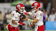 Sep 20, 2025; Honolulu, Hawaii, USA; Fresno State Bulldogs quarterback E.J. Warner (13) hands off the ball to running back Bryson Donelson (6).