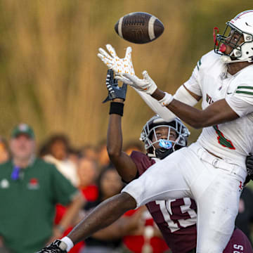 Lawrence North High School sophomore Monshun Sales (1) makes a catch in the end zone to score while being defended by Lawrence Central High School junior DJ Summers (13) during the first half of an IHSAA varsity football game, Friday, Aug. 23, 2024, at Lawrence Central High School.