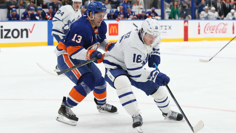 Nov 21, 2021; Elmont, New York, USA;  Toronto Maple Leafs right wing Mitchell Marner (16) skates the puck past New York Islanders center Mathew Barzal (13) in the second period at UBS Arena. Mandatory Credit: Tom Horak-USA TODAY Sports