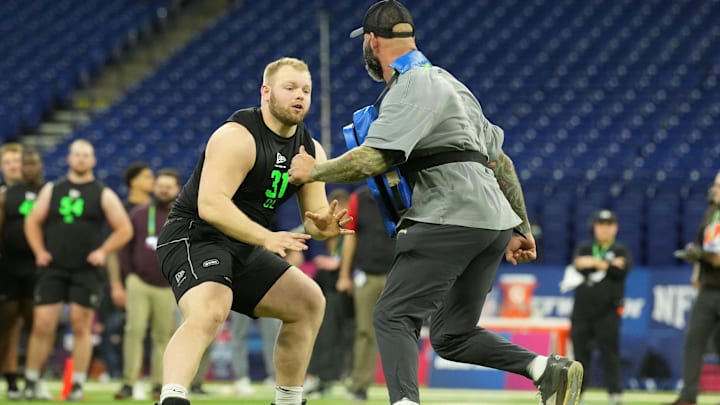 Mar 1, 2026; Indianapolis, IN, USA; Iowa offensive lineman Logan Jones (OL31) interacts with the Los Angeles Chargers assistant offensive line coach Nick Hardwick during the NFL Scouting Combine at Lucas Oil Stadium. Mandatory Credit: Kirby Lee-Imagn Images