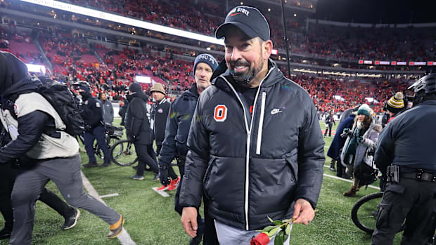 Dec 21, 2024; Columbus, Ohio, USA; Ohio State Buckeyes head coach Ryan Day celebrates the win as he carries a rose after the 