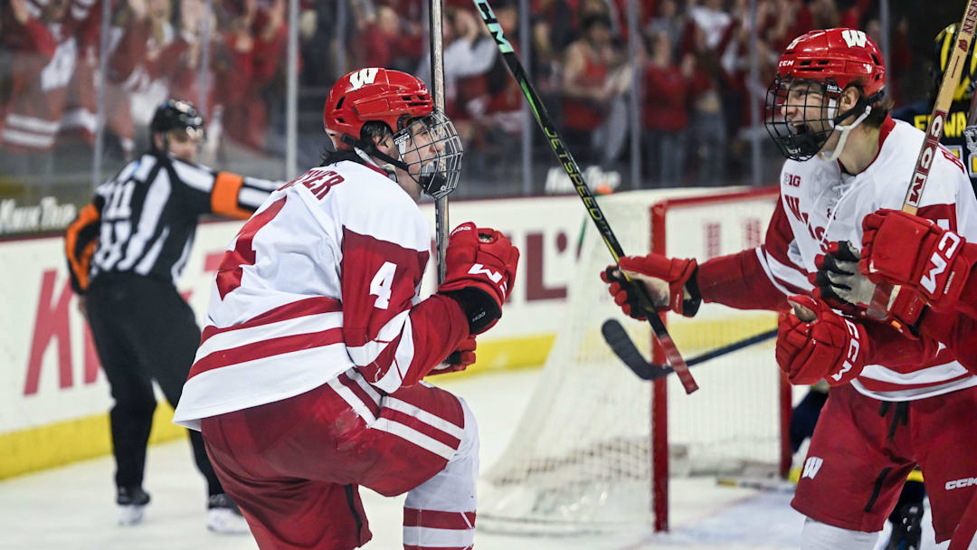 Wisconsin Badgers defenseman Ben Dexheimer (4) celebrates with Wisconsin Badgers left wing Ryan Botterill (21) after scoring a goal against the Michigan Wolverines during the third period in a game Saturday, January 25, 2025, at the Kohl Center in Madison, Wisconsin.