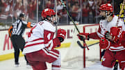 Wisconsin Badgers defenseman Ben Dexheimer (4) celebrates with Wisconsin Badgers left wing Ryan Botterill (21) after scoring a goal against the Michigan Wolverines during the third period in a game Saturday, January 25, 2025, at the Kohl Center in Madison, Wisconsin.