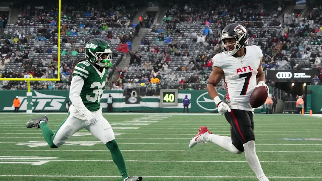 Nov 30, 2025; East Rutherford, New Jersey, USA; Atlanta Falcons running back Bijan Robinson (7) rushes for a touchdown against New York Jets cornerback Ja'Sir Taylor (36) during the first half at MetLife Stadium. 