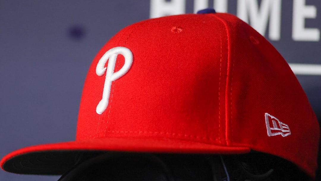 May 26, 2023; Atlanta, Georgia, USA; A detailed view of a Philadelphia Phillies hat and glove on the bench against the Atlanta Braves in the seventh inning at Truist Park. 