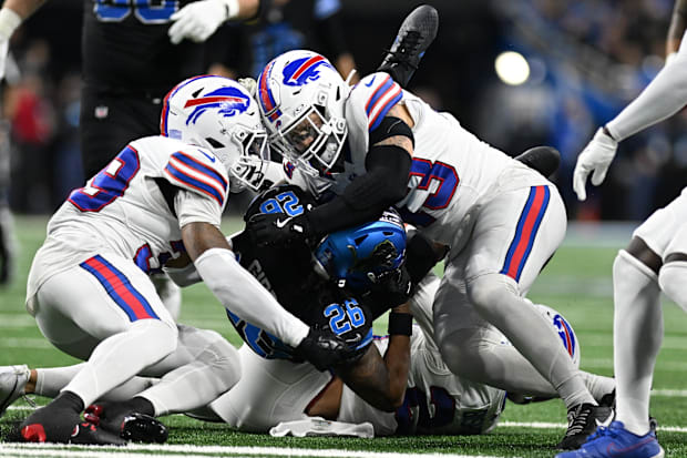 Buffalo Bills linebacker Terrel Bernard and cornerback Cam Lewis tackle Detroit Lions running back Jahmyr Gibbs.