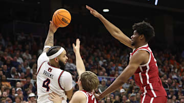Feb 4, 2025; Auburn, Alabama, USA;  Auburn Tigers forward Johni Broome (4) makes a pass over Oklahoma Sooners forward Mohamed Wague (5) and guard Dayton Forsythe (7) during the second half at Neville Arena. Mandatory Credit: John Reed-Imagn Images
