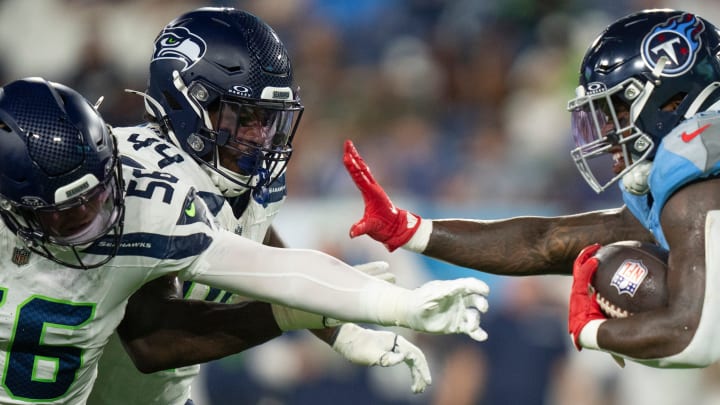 Tennessee Titans running back Hassan Haskins (25) powers his way forward against Seattle's Easton Gibbs (56) and Jamie Sheriff (44) during their game at Nissan Stadium in Nashville, Tenn., Saturday, Aug. 17, 2024.