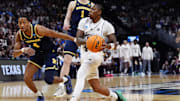 Texas A&M Aggies guard Wade Taylor IV (4) dribbles the ball against Michigan Wolverines guard Nimari Burnett (4) during the first half in the second round of the NCAA Tournament  at Ball Arena.