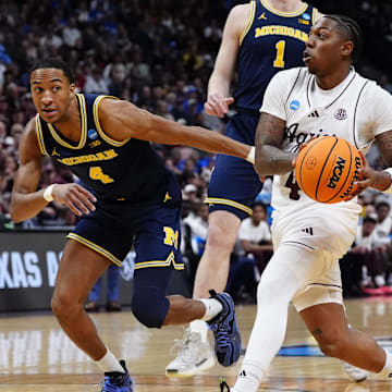 Texas A&M Aggies guard Wade Taylor IV (4) dribbles the ball against Michigan Wolverines guard Nimari Burnett (4) during the first half in the second round of the NCAA Tournament  at Ball Arena.