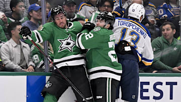 Mar 2, 2025; Dallas, Texas, USA; Dallas Stars defenseman Brendan Smith (2) and center Mavrik Bourque (22) and St. Louis Blues right wing Alexey Toropchenko (13) crash into the boards during the first period at the American Airlines Center. Mandatory Credit: Jerome Miron-Imagn Images