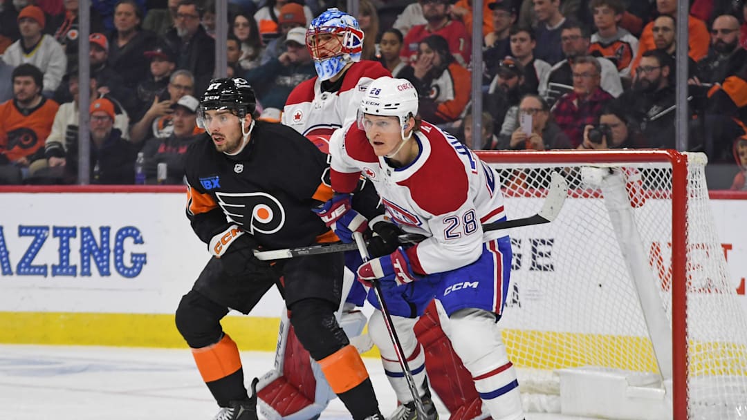 Mar 27, 2025; Philadelphia, Pennsylvania, USA; Philadelphia Flyers left wing Noah Cates (27) and Montreal Canadiens center Christian Dvorak (28) in front of goaltender Jakub Dobes (75) during the second period at Wells Fargo Center.