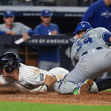 Sep 11, 2024; Bronx, New York, USA; New York Yankees shortstop Anthony Volpe (11) scores as Kansas City Royals catcher Freddy Fermin (34) can not handle the throw during the tenth inning  at Yankee Stadium. Mandatory Credit: Vincent Carchietta-Imagn Images