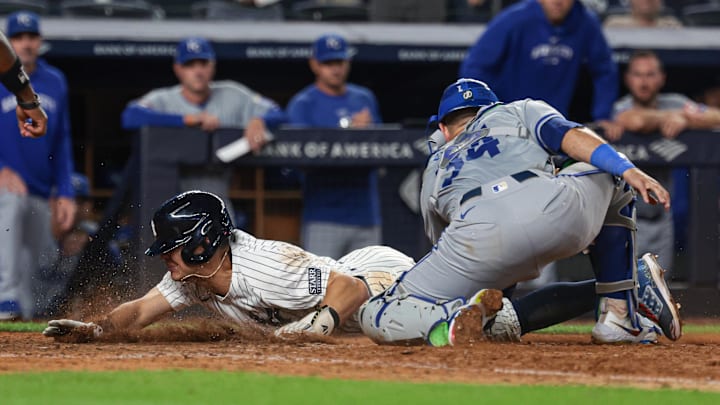 Sep 11, 2024; Bronx, New York, USA; New York Yankees shortstop Anthony Volpe (11) scores as Kansas City Royals catcher Freddy Fermin (34) can not handle the throw during the tenth inning  at Yankee Stadium. Mandatory Credit: Vincent Carchietta-Imagn Images