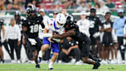 Aug 28, 2025; Tampa, Florida, USA; Boise State Broncos quarterback Maddux Madsen (4) is brought down by South Florida Bulls linebacker Jhalyn Shuler (7) in the third quarter at Raymond James Stadium. 