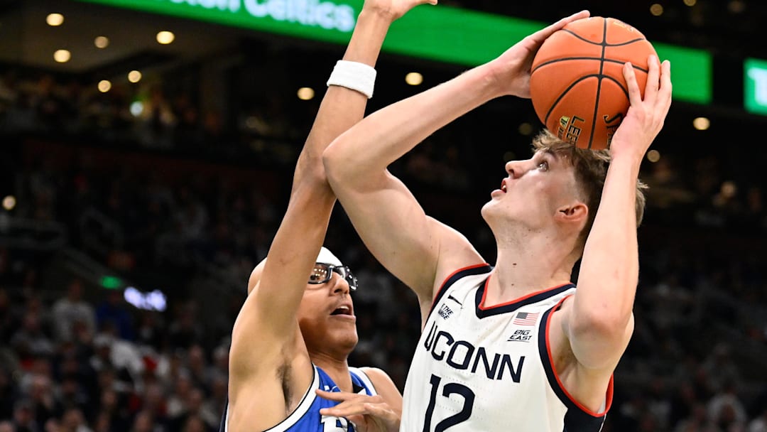 Nov 15, 2025; Boston, Massachusetts, USA; UConn Huskies center Eric Reibe (12) shoots against the defense of BYU Cougars center Xavion Staton (33) during the first half at TD Garden.