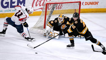 Providence Bruins goalie Michael DiPietro and defender Frederic Brunet deflect the puck from Thunderbird Dylan Peterson away from the Providence goal.