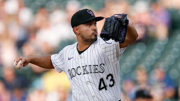 Colorado Rockies starting pitcher Anthony Molina pitches while wearing a white uniform with black pinstripes.