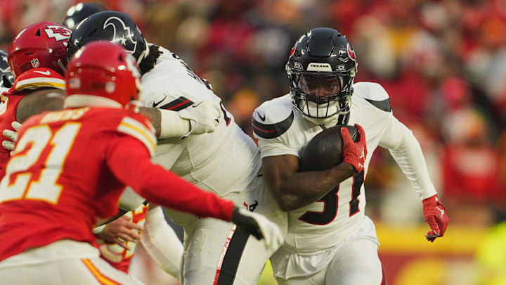 Jan 18, 2025; Kansas City, Missouri, USA; Houston Texans running back Dameon Pierce (31) runs the ball against Kansas City Chiefs safety Jaden Hicks (21) during the third quarter of a 2025 AFC divisional round game at GEHA Field at Arrowhead Stadium. Mandatory Credit: Jay Biggerstaff-Imagn Images