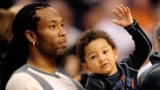 Then-Arizona Cardinals wide receiver Larry Fitzgerald sits courtside with son Devin Fitzgerald at a Phoenix Suns game in 2010.