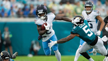 Dec 29, 2024; Jacksonville, Florida, USA; Tennessee Titans running back Tyjae Spears (2) runs the ball against Jacksonville Jaguars safety Andre Cisco (5) in the first quarter at EverBank Stadium. Mandatory Credit: Jeremy Reper-Imagn Images