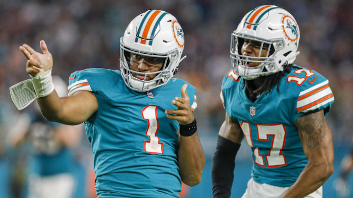 Jan 9, 2022; Miami Gardens, Florida, USA; Miami Dolphins quarterback Tua Tagovailoa (1) reacts with wide receiver Jaylen Waddle (17) after running with the football for a first down against the New England Patriots during the fourth quarter at Hard Rock Stadium. 