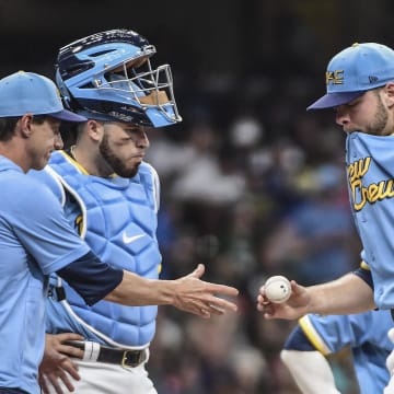 Jun 25, 2022; Milwaukee, Wisconsin, USA; Milwaukee Brewers pitcher Corbin Burnes (39) hands the ball to manager Craig Counsell during a pitching change in the eighth inning of the game against the Toronto Blue Jays at American Family Field.