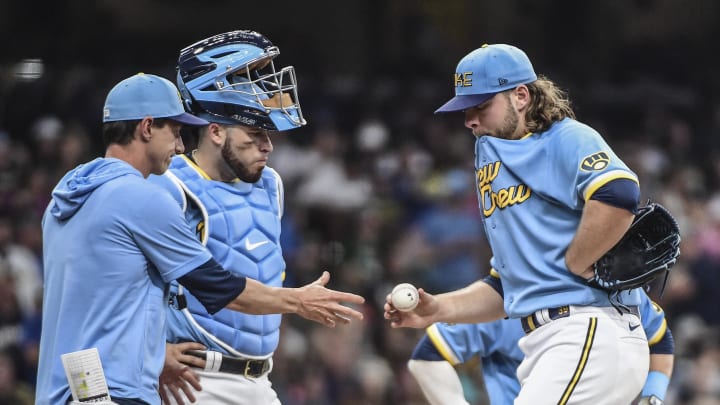 Jun 25, 2022; Milwaukee, Wisconsin, USA; Milwaukee Brewers pitcher Corbin Burnes (39) hands the ball to manager Craig Counsell during a pitching change in the eighth inning of the game against the Toronto Blue Jays at American Family Field.