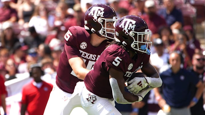 Sep 7, 2024; College Station, Texas, USA; Texas A&M Aggies quarterback Conner Weigman (15) hands the ball to running back Amari Daniels (5) during the first quarter against the McNeese State Cowboys at Kyle Field.