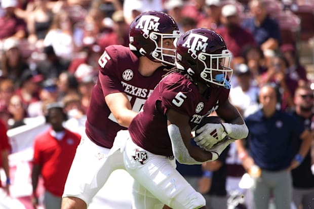  Texas A&M Aggies quarterback Conner Weigman (15) hands the ball to running back Amari Daniels (5). 