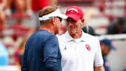 Sep 20, 2025; Norman, Oklahoma, USA;  Auburn Tigers head coach Hugh Freeze (left) speaks with Oklahoma Sooners head coach Brent Venables (right) before the game at Gaylord Family-Oklahoma 