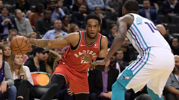 Toronto Raptors forward Oshae Brissett (12) dribbles the ball against Charlotte Hornets forward Michael Kidd-Gilchrist (14) .