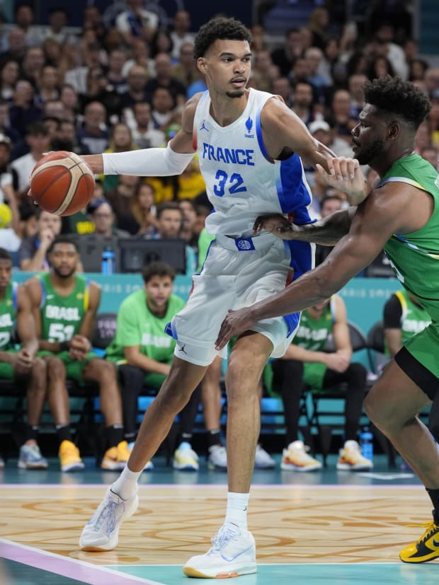 France power forward Victor Wembanyama (32) controls the ball against Brazil centre Cristiano Felicio (6) in Paris.