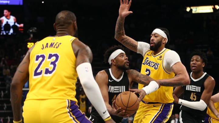 Apr 12, 2024; Memphis, Tennessee, USA; Memphis Grizzlies guard Jordan Goodwin (4) drives to the basket between Los Angeles Lakers forward LeBron James (23) and forward Anthony Davis (3) during the second half at FedExForum. 