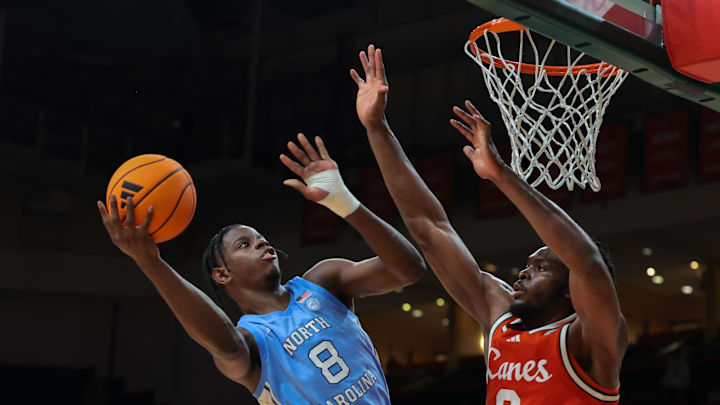Feb 10, 2026; Coral Gables, Florida, USA; North Carolina Tar Heels forward Caleb Wilson (8) drives to the basket against Miami Hurricanes center Ernest Udeh Jr. (8) during the second half at Watsco Center. Mandatory Credit: Sam Navarro-Imagn Images